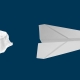 Crumpled paper ball beside a folded white paper airplane on a navy background